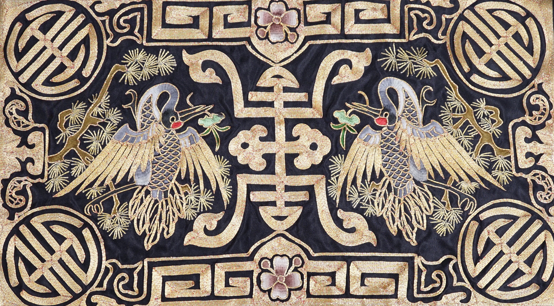 A Chinese silk textile phoenix panel embroidered with gold thread, 45cm x 25cm